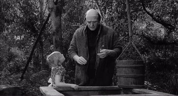 Movie still from “Young Frankenstein” (1974), directed by Mel Brooks – An older man and a young girl are standing in a forest; Medium shot, Over the shoulder angle