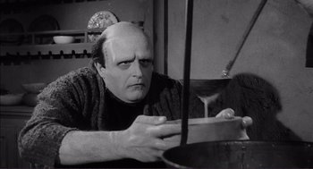 Movie still from “Young Frankenstein” (1974), directed by Mel Brooks – A man with a bald head is stirring something in a pan; Medium shot, Low angle