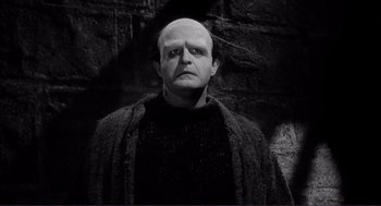 Movie still from “Young Frankenstein” (1974), directed by Mel Brooks – An old man with a bald head wearing a sweater; Medium shot, Low angle
