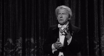 Movie still from “Young Frankenstein” (1974), directed by Mel Brooks – An older man in a tuxedo clapping his hands; Medium shot, Low angle