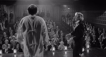 Movie still from “Young Frankenstein” (1974), directed by Mel Brooks – A man and a woman in front of an audience in a theater; Medium shot, Over the shoulder angle