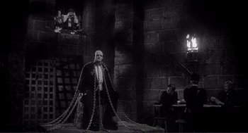 Movie still from “Young Frankenstein” (1974), directed by Mel Brooks – A man in chains standing in a dark room; Wide shot, Low angle
