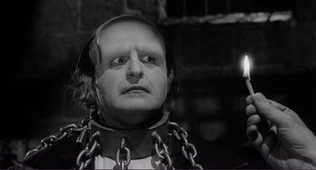 Movie still from “Young Frankenstein” (1974), directed by Mel Brooks – A man in chains wearing a black and white image; Close Up shot, Low angle