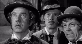 Movie still from “Young Frankenstein” (1974), directed by Mel Brooks – Two men in hats and ties are posing for a picture; Close Up shot, Low angle
