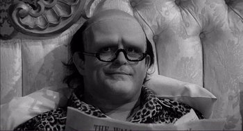 Movie still from “Young Frankenstein” (1974), directed by Mel Brooks – A bald man with glasses is reading a newspaper; Close Up shot, Low angle