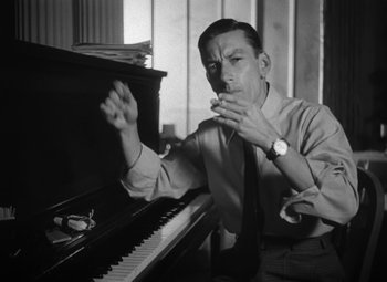 Movie still from “Young Man with a Horn” (1950), directed by Michael Curtiz – A black and white photo of a man sitting at a piano; Medium shot, High angle
