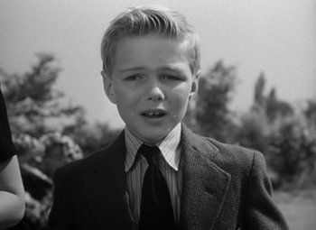 Movie still from “Young Man with a Horn” (1950), directed by Michael Curtiz – A young boy in a suit and a tie; Close Up shot, High angle