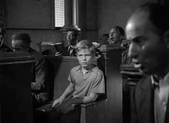 Movie still from “Young Man with a Horn” (1950), directed by Michael Curtiz – Black and white photograph of people sitting in church pews; Medium shot, High angle
