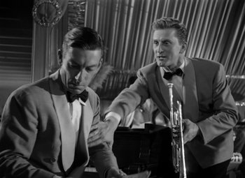 Movie still from “Young Man with a Horn” (1950), directed by Michael Curtiz – Two men in tuxedos and bow - ties are playing the trumpet; Medium shot, Low angle