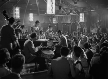 Movie still from “Young Man with a Horn” (1950), directed by Michael Curtiz – A group of men and women sitting in a room; Wide shot, High angle