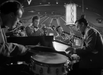 Movie still from “Young Man with a Horn” (1950), directed by Michael Curtiz – A black and white photo of men playing musical instruments; Medium shot, Low angle