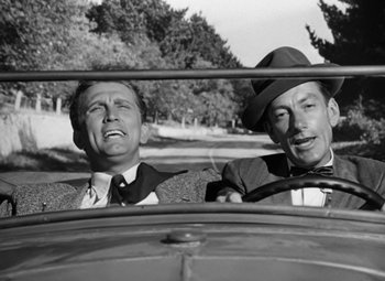 Movie still from “Young Man with a Horn” (1950), directed by Michael Curtiz – A couple of men sitting in the back seat of a car; Close Up shot, Low angle