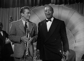 Movie still from “Young Man with a Horn” (1950), directed by Michael Curtiz – Two men in suits are standing next to each other; Medium shot, Low angle