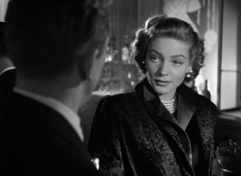 Movie still from “Young Man with a Horn” (1950), directed by Michael Curtiz – An old photo of a man and a woman; Close Up shot, Over the shoulder angle