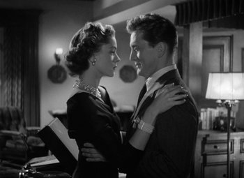 Movie still from “Young Man with a Horn” (1950), directed by Michael Curtiz – A man and a woman embracing each other in front of a mirror; Medium shot, Low angle