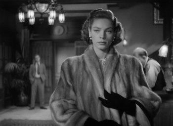 Movie still from “Young Man with a Horn” (1950), directed by Michael Curtiz – A black and white photo of a woman in a fur coat; Medium shot, Over the shoulder angle