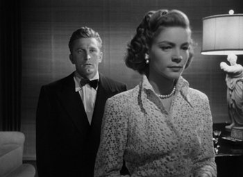 Movie still from “Young Man with a Horn” (1950), directed by Michael Curtiz – A man and a woman standing next to each other in a room; Medium shot, Low angle