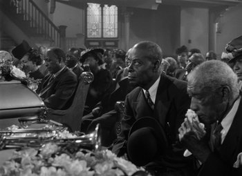 Movie still from “Young Man with a Horn” (1950), directed by Michael Curtiz – A black and white photo of people sitting at a table; Medium shot, High angle