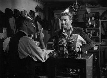 Movie still from “Young Man with a Horn” (1950), directed by Michael Curtiz – Two men sitting at a table in a kitchen; Medium shot, Over the shoulder angle