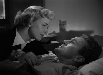 Movie still from “Young Man with a Horn” (1950), directed by Michael Curtiz – An old photo of a man and a woman laying in a bed; Medium shot, Low angle