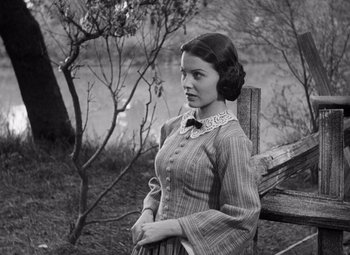 Movie still from “Young Mr. Lincoln” (1939), directed by John Ford – A woman sitting on a wooden bench in a field; Medium shot, High angle