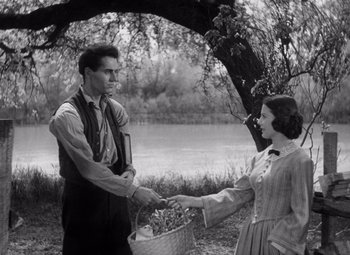 Movie still from “Young Mr. Lincoln” (1939), directed by John Ford – A man and a woman holding a basket in a field; Medium shot, High angle