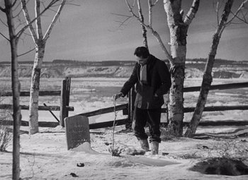 Movie still from “Young Mr. Lincoln” (1939), directed by John Ford – A man standing next to a grave in the snow; Wide shot, Over the shoulder angle