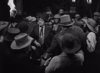 Movie still from “Young Mr. Lincoln” (1939), directed by John Ford – A group of men wearing hats and suits in a crowd; Medium shot, High angle