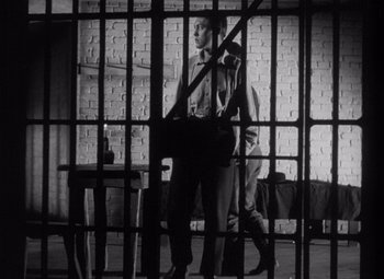 Movie still from “Young Mr. Lincoln” (1939), directed by John Ford – Two men walking through a jail cell with bars around them; Wide shot, Low angle
