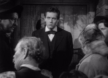 Movie still from “Young Mr. Lincoln” (1939), directed by John Ford – A black and white photo of a man in a suit and bow tie; Medium shot, Over the shoulder angle