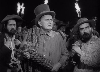 Movie still from “Young Mr. Lincoln” (1939), directed by John Ford – A group of men standing next to each other holding torches; Medium shot, Low angle