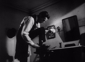 Movie still from “Young Mr. Lincoln” (1939), directed by John Ford – A black and white photo of a man working in a room; Medium shot, Low angle
