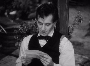 Movie still from “Young Mr. Lincoln” (1939), directed by John Ford – A man in a vest and bow tie reading a letter; Close Up shot, Over the shoulder angle
