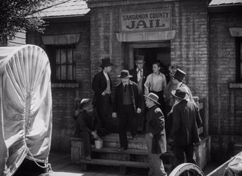 Movie still from “Young Mr. Lincoln” (1939), directed by John Ford – A black and white photo of a group of men standing in front of a jail; Wide shot, Low angle