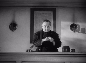 Movie still from “Young Mr. Lincoln” (1939), directed by John Ford – An older man standing in front of a clock; Medium shot, Low angle