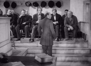 Movie still from “Young Mr. Lincoln” (1939), directed by John Ford – An old photo of a group of men sitting in a circle; Wide shot, Over the shoulder angle