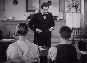 Movie still from “Young Mr. Lincoln” (1939), directed by John Ford – An old photo of a man standing in front of a group of people; Medium shot, Over the shoulder angle