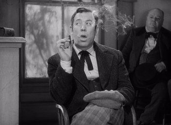 Movie still from “Young Mr. Lincoln” (1939), directed by John Ford – A man smoking a cigarette while sitting in a chair; Medium shot, Low angle