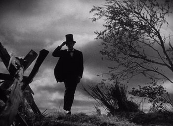 Movie still from “Young Mr. Lincoln” (1939), directed by John Ford – A man in a top hat walking on a hill; Wide shot, Low angle