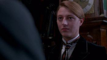 Movie still from “Young Sherlock Holmes” (1985), directed by Barry Levinson – A man in a suit and tie looking into a mirror; Close Up shot, Low angle