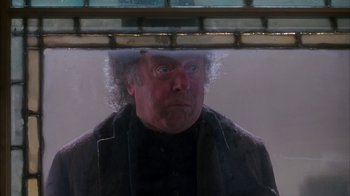 Movie still from “Young Sherlock Holmes” (1985), directed by Barry Levinson – A man looking out of a window at the camera; Close Up shot, Low angle