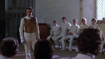 Movie still from “Young Sherlock Holmes” (1985), directed by Barry Levinson – A group of men sitting in a room next to each other; Medium shot, Over the shoulder angle