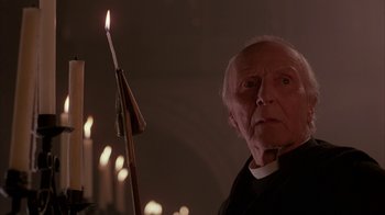 Movie still from “Young Sherlock Holmes” (1985), directed by Barry Levinson – An older man holding a candle in a dark room; Close Up shot, Low angle