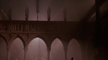 Movie still from “Young Sherlock Holmes” (1985), directed by Barry Levinson – A cathedral with arches and statues in the middle of the room; Extreme Wide shot, Low angle