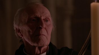 Movie still from “Young Sherlock Holmes” (1985), directed by Barry Levinson – An old man with a white beard looking at the camera; Close Up shot, Low angle