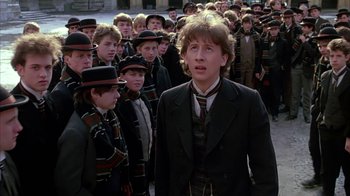 Movie still from “Young Sherlock Holmes” (1985), directed by Barry Levinson – A group of young men standing next to each other on a street; Medium shot, High angle