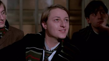 Movie still from “Young Sherlock Holmes” (1985), directed by Barry Levinson – A young man wearing a striped tie and a sweater; Close Up shot, Low angle