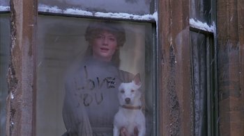 Movie still from “Young Sherlock Holmes” (1985), directed by Barry Levinson – A woman and a white dog are in a window; Medium shot, Over the shoulder angle