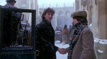 Movie still from “Young Sherlock Holmes” (1985), directed by Barry Levinson – Two people are shaking hands on a snowy day; Medium shot, Over the shoulder angle