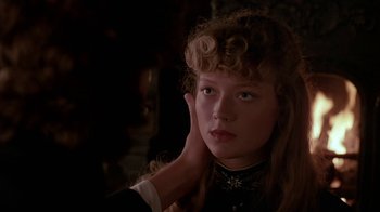 Movie still from “Young Sherlock Holmes” (1985), directed by Barry Levinson – A young woman with long curly hair wearing a black dress; Close Up shot, Over the shoulder angle
